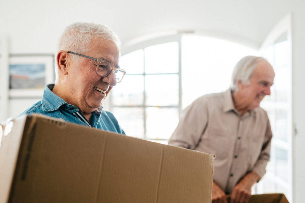 two seniors moving cardboard boxes